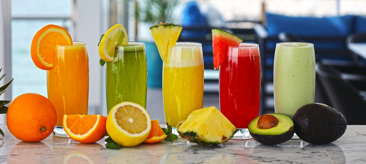 A vibrant array of fresh fruit juices with garnishes, offering a healthy and refreshing drink option.